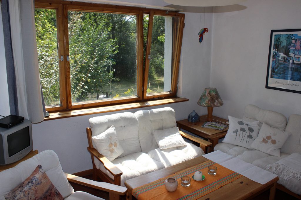 Uckermark Ferienhaus Wohnzimmer mit Klavier und TV.