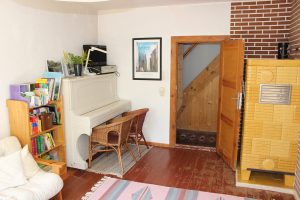 Uckermark Ferienhaus Wohnzimmer mit Klavier und TV.